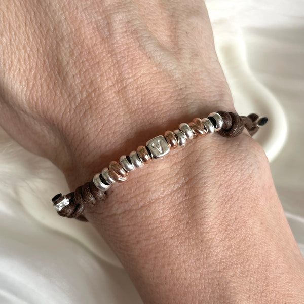 B010 Bracciale con cordino cerato e rondelle + lettera al centro o altro elemento a scelta a parte