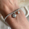 B0279 Bracciale con rondelline piccole, perla e fiore pendente “grazie maestra”