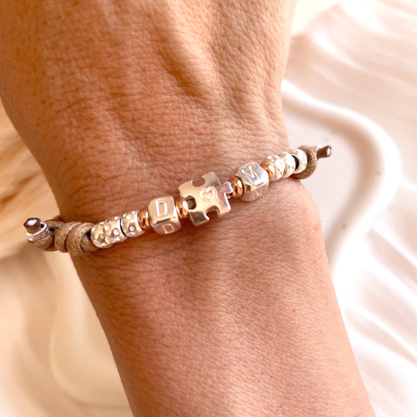 B0299 Bracciale in cordino cerato di coppia con puzzle, iniziali cubo e granelli
