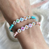 B0272 Bracciale con palline in pasta di turchese o corallo da 3mm con lettere MOM o MAMMA e margherite
