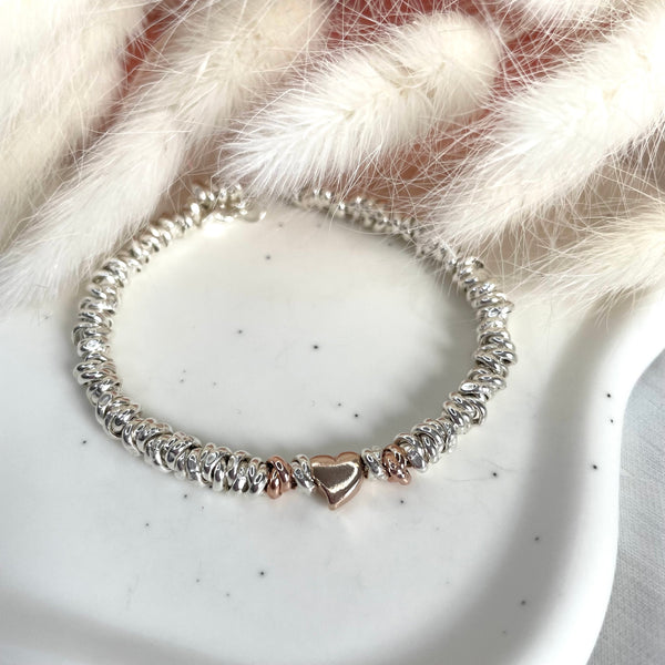 B127 Bracciale con nodi e cuore rosato passante al centro