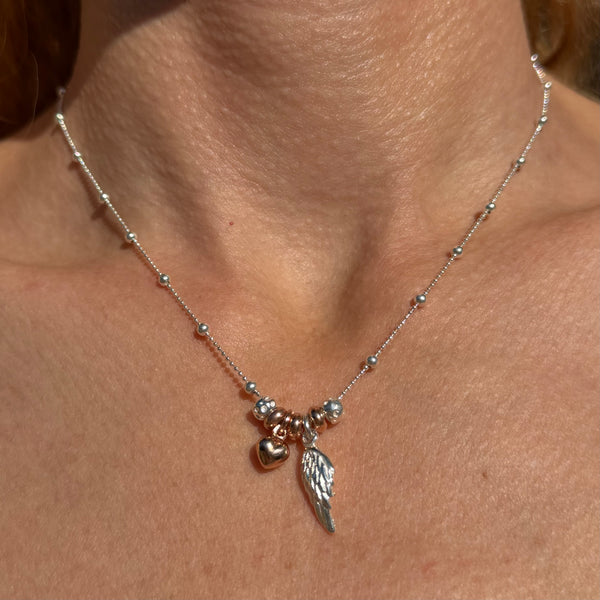 CL126 Collana palline alternate in argento con ala d’angelo pendente e cuore