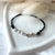 B162 Bracciale batticuori con cordino cerato sottile, cuoricini e rondelle rosate