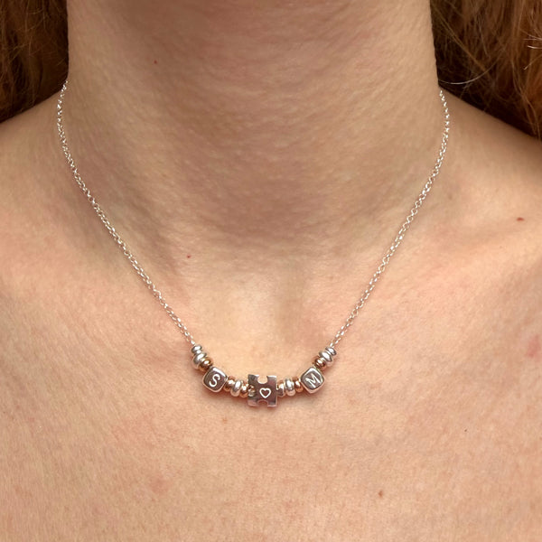 CL0159 Collana rolò in argento con rondelle, iniziali cubo e puzzle passante