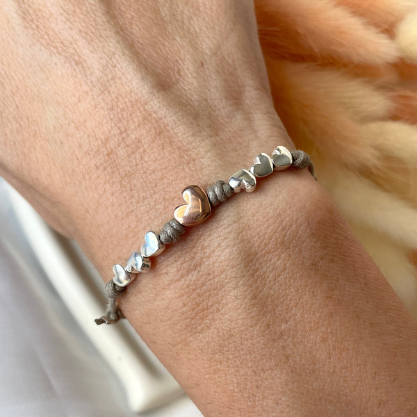 B0176 Bracciale batticuori con cordino cerato sottile, cuoricini e cuore rosato al centro