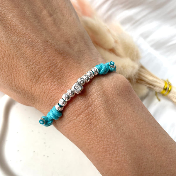 B011 Bracciale con cordino cerato e granelli nuovi + lettera al centro o altro elemento