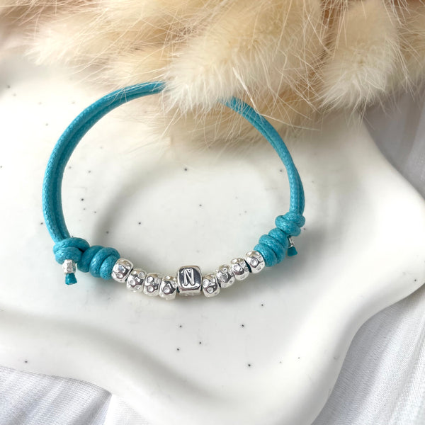 B011 Bracciale con cordino cerato e granelli nuovi + lettera al centro o altro elemento