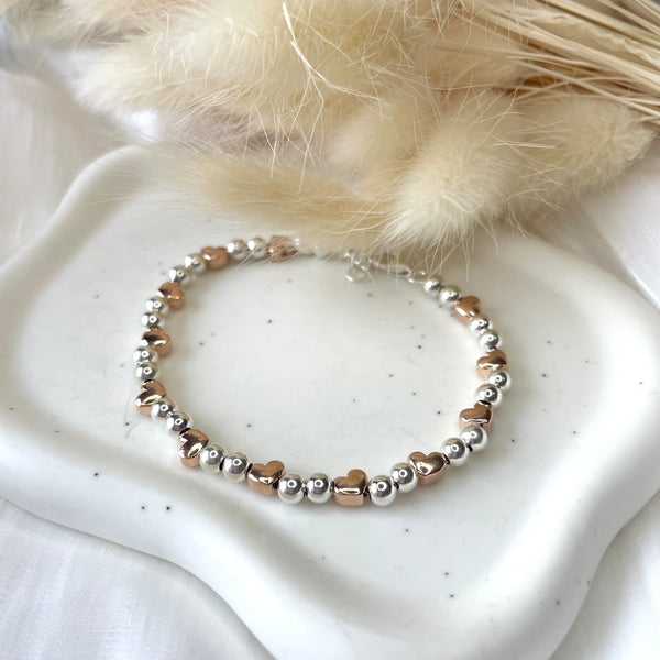 B0168 Bracciale palline piccole con cuori passanti rosati