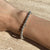 B088 Bracciale con palline intervallate a nodi e 3 cuori intreccio