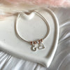 B0269 Bracciale semi rigido con rondelle rosate, granello, cuore e iniziali pendenti