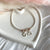 B0269 Bracciale semi rigido con rondelle rosate, granello, cuore e iniziali pendenti
