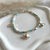 B0289 Bracciale con cubetti, palline pasta di turchese e ciondoli: pesce, barca e conchiglia